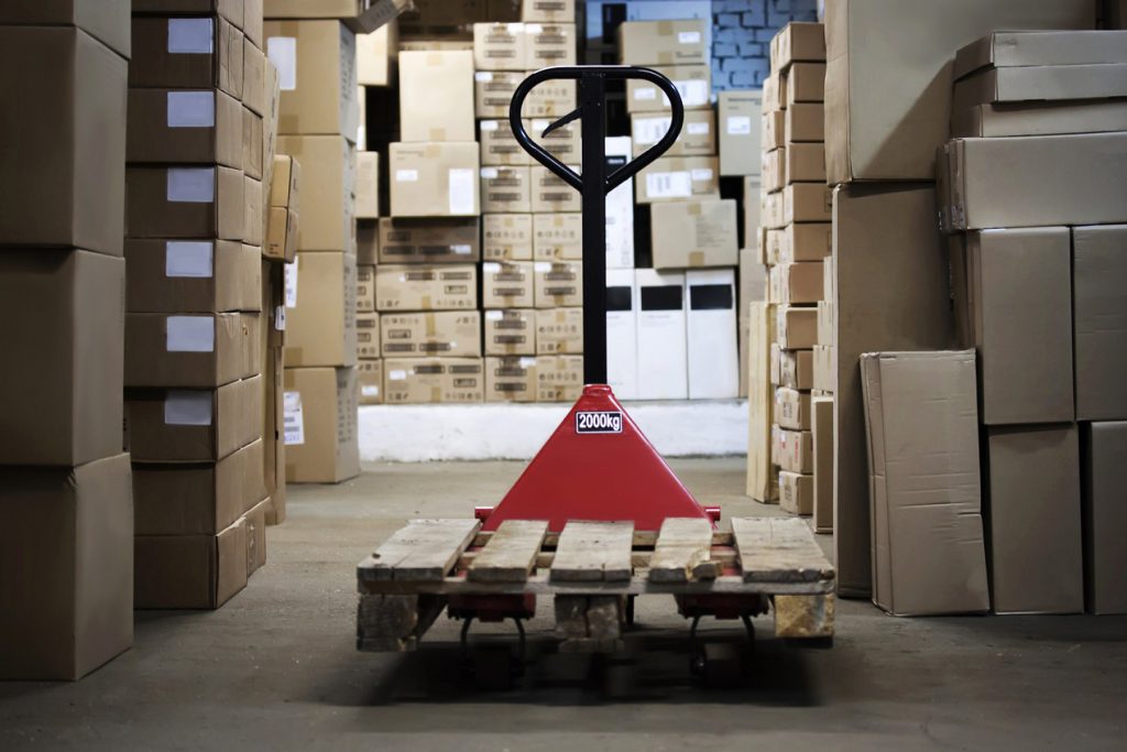 Warehouse with goods in boxes and trolleys for transportation of goods close-up