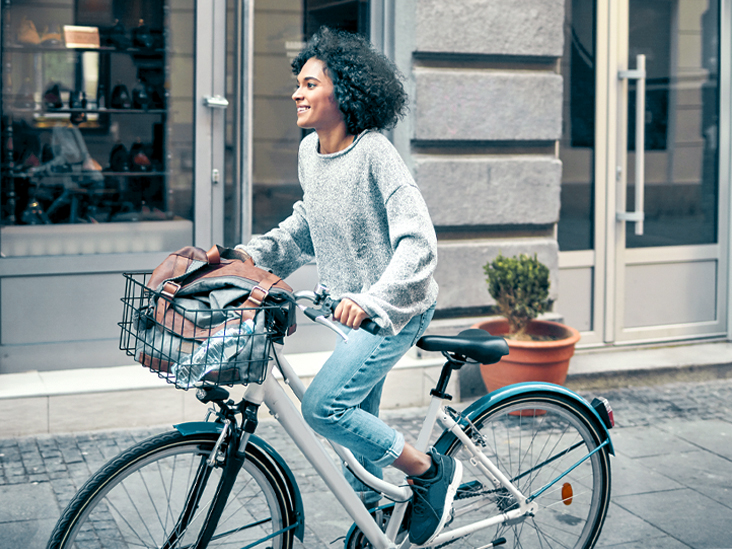 Woman-Riding-Rented-Bicycle-In-A-City.-Cycling-and-smiling-