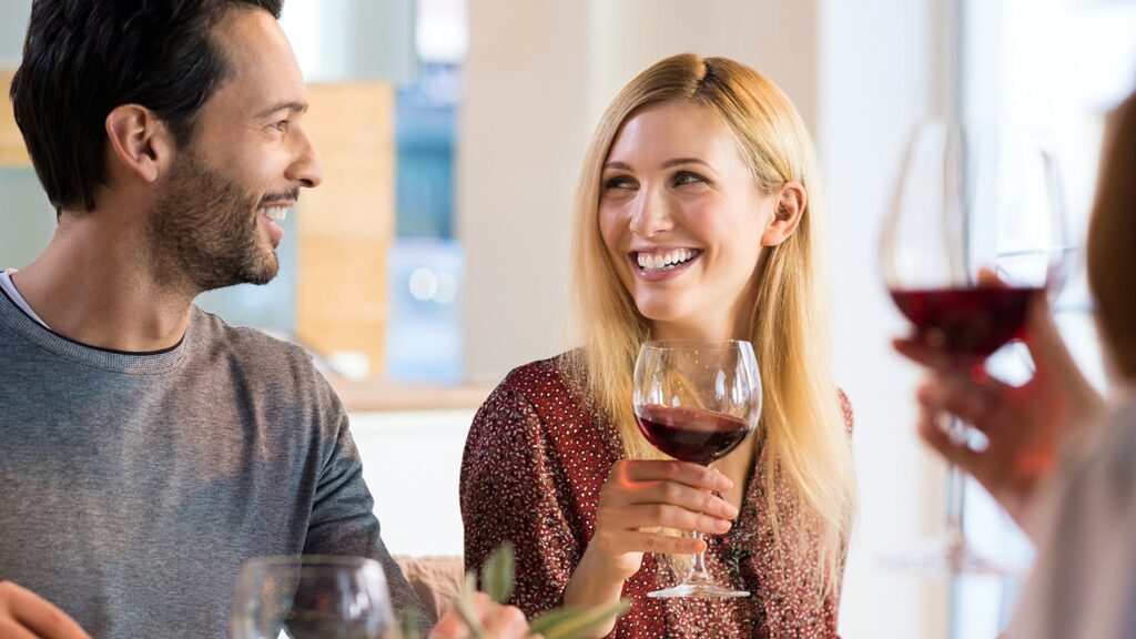 couple smiling while drinking wine