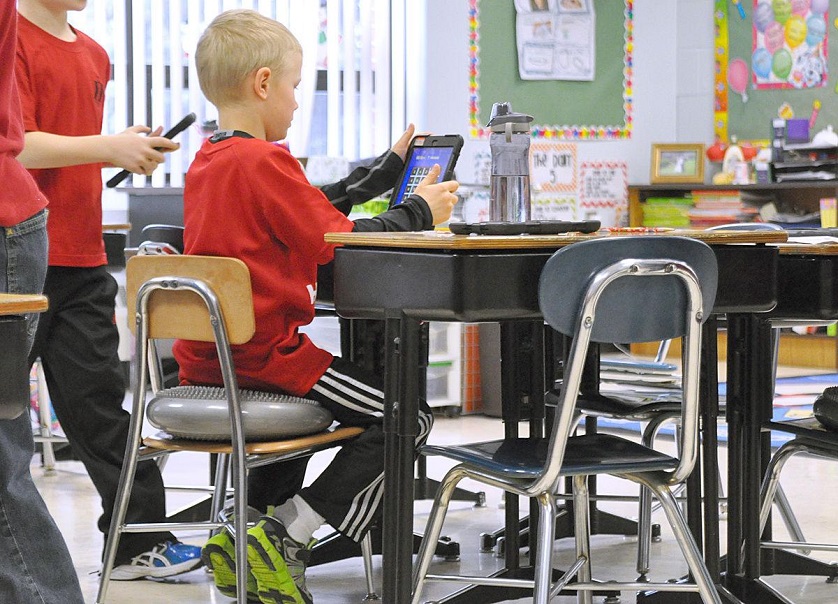 kid seating on cushion in classroom