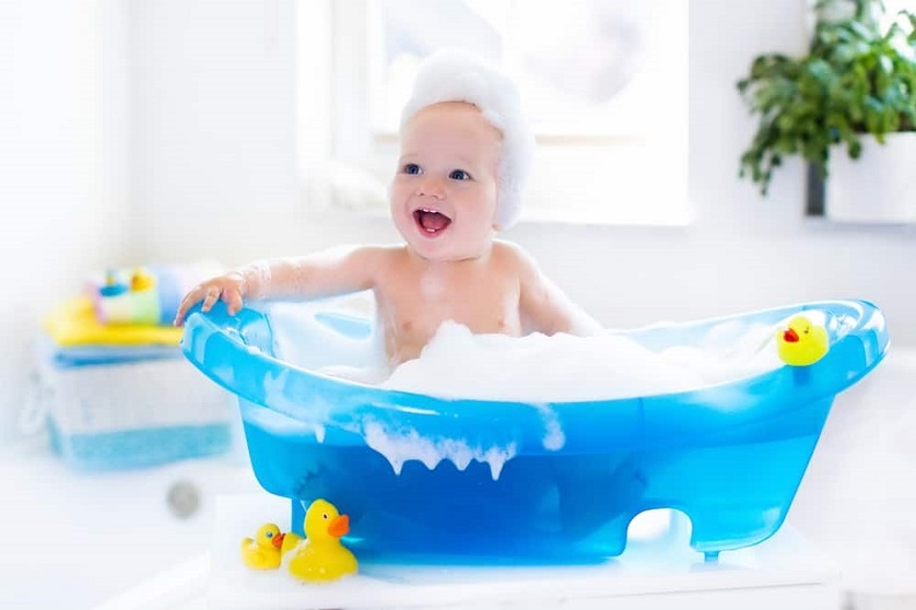 baby taking a bath in a blue bathtub