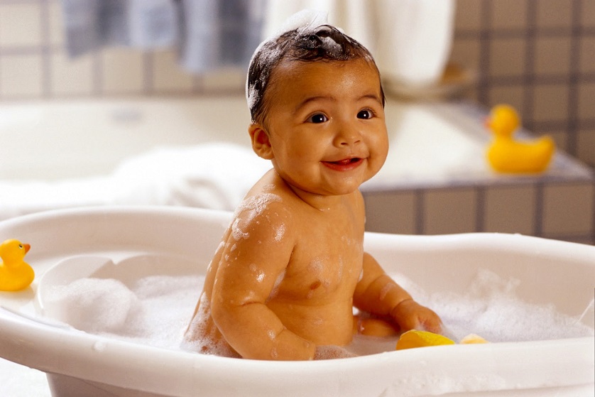 cute baby in bath tub with ducks