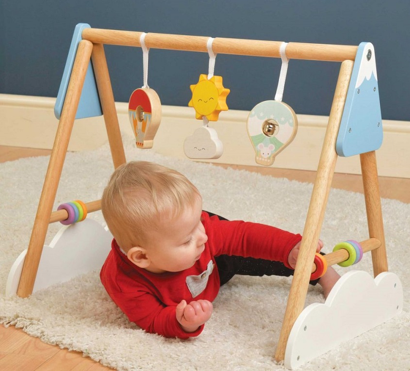 picture of a baby boy under a play gym on the floor