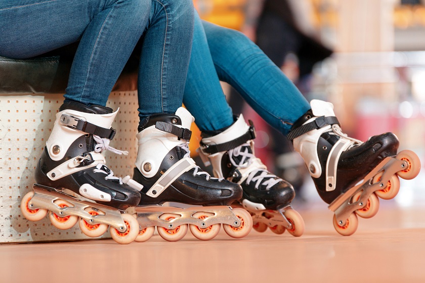 picture of perons sitting on a bench wearing hard shell inline skates