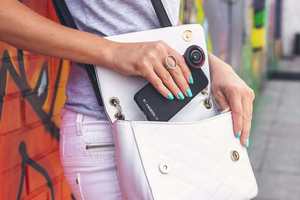 Woman puts her cellphone vegan crossbody bag