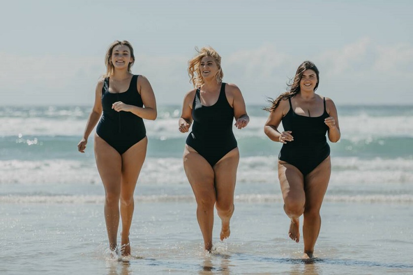 women in swimwear running on the beach 