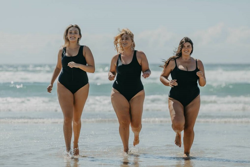 women in swimwear running on the beach