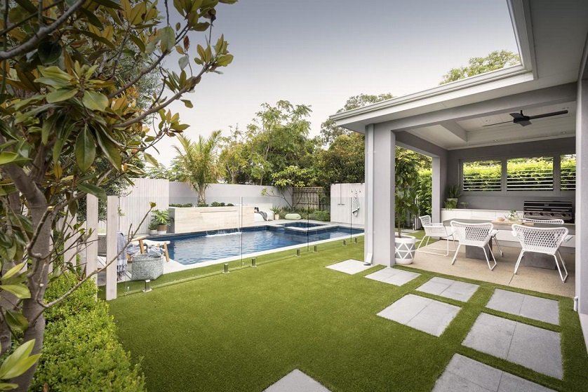 outdoor view of a home with a pool in the garden