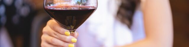 woman holding a glass of Pinot noir wine